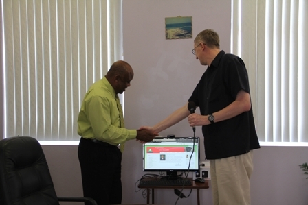 St. Kitts and Nevis Circle of Care representative Mr. Jean Van Eeden handing over lap top computer to Minister of Health and Social Development Hon. Hensley Daniel